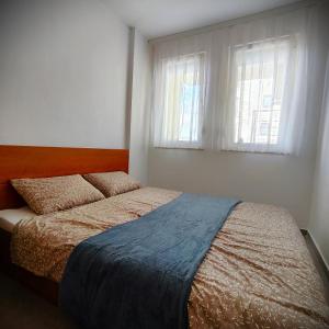 um quarto com uma cama e uma janela em Central Park Apartment em Pristina