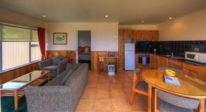 a kitchen and living room with a couch and a table at Islander Lodge Apartments in Burnt Pine