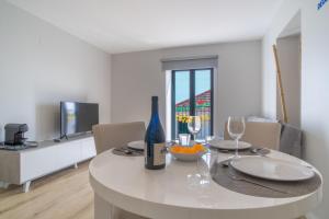 a dining room with a table with a bottle of wine at Buzz Apartment in Jardim do Mar