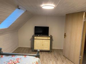 een slaapkamer met een tv en een bed in een kamer bij Nordwindoase in Grünendeich