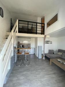 salon ze schodami i kuchnią w obiekcie Plage à 100 m - Appart Moderne ! w mieście Brétignolles-sur-Mer
