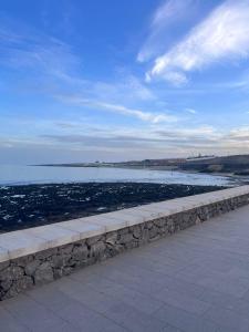 un mur en pierre à côté d'une masse d'eau dans l'établissement Mar y reina, à Puerto del Rosario