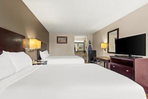 a hotel room with two beds and a flat screen tv at Americas Best Value Inn Laurel in Laurel