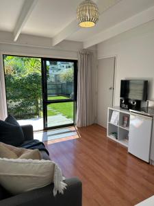 a living room with a couch and a large window at Evolve Bach in Whitianga