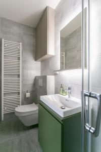 ein Badezimmer mit einem Waschbecken, einem WC und einem Spiegel in der Unterkunft LUONG Europe Apartments in Prag