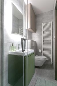 ein Badezimmer mit einem grünen Waschbecken und einem WC in der Unterkunft LUONG Europe Apartments in Prag
