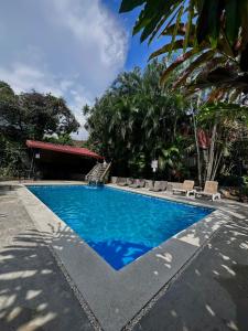 una piscina de agua azul en un complejo en Brillasol Airport Hotel en Alajuela
