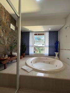 a large bath tub in a bathroom with a window at CasaIvan in Florianópolis
