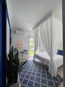 a bedroom with a white canopy bed and a blue rug at CasaIvan in Florianópolis
