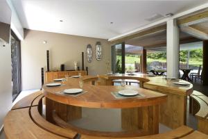 une salle à manger avec une grande table en bois dans l'établissement Betikure Parc Lodge, à Bourail