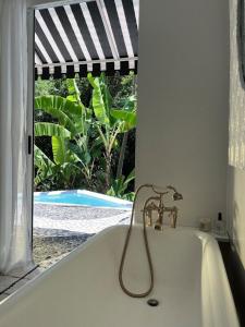 a bath tub in a bathroom with a window at CasaIvan in Florianópolis