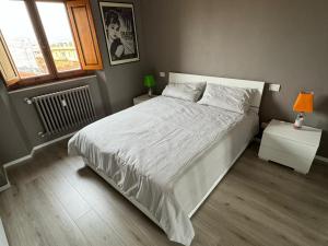 a bedroom with a large white bed and a window at Casa i Portici in Arezzo