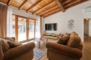 a living room with two couches and a tv at Stunning Villa for 10 people with large heated pool-50m2, jacuzzi and gym - by TA Leut Agency in Privlaka