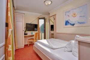 a hotel room with a bed and a desk at Landhotel Sternwirt - Das Wellnesshotel zwischen Nürnberg und Amberg in Högen
