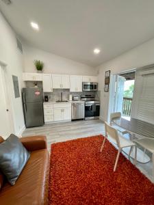 cocina con sofá y mesa con alfombra roja en Modern Riverview Apartments en Fort Lauderdale