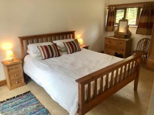 a bedroom with a wooden bed with two night stands and two lamps at Holsworthy Holiday Cottages in Holsworthy