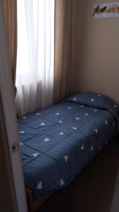 małe łóżko w pokoju z oknem w obiekcie Lindo Departamento en El Tabo, Condominio Vista Mar w mieście El Tabo