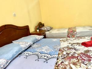 a bedroom with two beds and a table with a night stand at soleado apartamento al lado de la preciosa medina , a 3 minutos de la playa andando I in Asilah