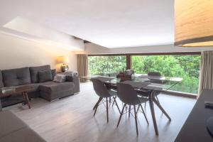 Una sala de estar con una mesa y sillas y un sofá. en Apartamentos Santa Lucia, en Cabezón de la Sal