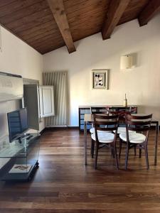 une salle à manger avec une table, des chaises et une télévision dans l'établissement Casa Petrucci 2 centro storico, à Forlì