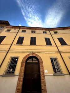 un edificio con una puerta y un arco delante de él en Casa Petrucci 2 centro storico, en Forlì