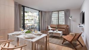 sala de estar con mesa y sillas en Zip Housing El Golf, en Santiago