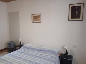 ein Schlafzimmer mit einem Bett und zwei Bildern an der Wand in der Unterkunft Appartamento Prima Torre in Primaluna