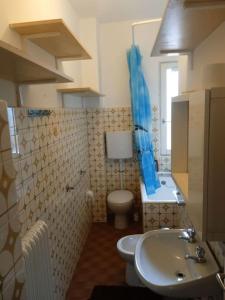 ein Badezimmer mit einem WC und einem Waschbecken mit einem blauen Duschvorhang in der Unterkunft Appartamento Prima Torre in Primaluna