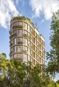 een hoog gebouw met bomen ervoor bij ONTO Tonalá Mexico City in Mexico-Stad