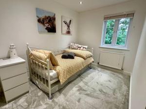 a bedroom with a bed and a window at Bourton House Windrush Lake in South Cerney