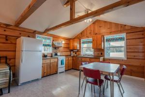 eine Küche mit einem Tisch und einem weißen Kühlschrank in der Unterkunft Big Blue Lake Cottages, LLC - Cottage #1 in Holton