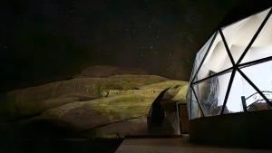sypialnia z łóżkiem w pokoju z oknem w obiekcie Bronze Mountains Camp Wadi Rum w Akabie