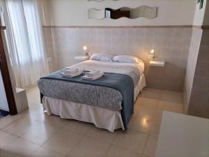 1 dormitorio con 1 cama con 2 toallas en Típico y pintoresco patio de vecinos, con encanto, en Sevilla