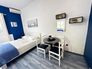 Studio Apartments Promajna في بروماجنا: غرفة نوم بسرير وطاولة وكراسي