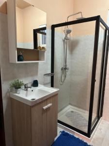een badkamer met een wastafel en een douche bij Home Thomas in Lombada dos Marinheiros