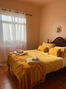 een slaapkamer met een bed met twee handdoeken erop bij Home Thomas in Lombada dos Marinheiros
