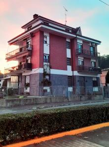 un edificio rosso e bianco sul lato di una strada di Delponte Residence a Rocchetta Tanaro