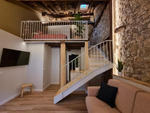 a staircase in a living room with a stone wall at Alojamientos El lecho in Treceño