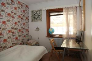 a bedroom with a bed and a desk and a window at Nordic character in Vidsel