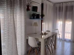 ein Esszimmer mit einem Tisch, Stühlen und einem Fenster in der Unterkunft Apartamento La Doncella in Alcalá de Henares