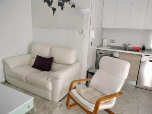 sala de estar con sofá blanco y silla en Apartamento La Doncella, en Alcalá de Henares