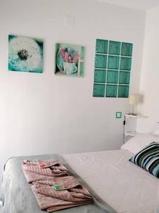 1 dormitorio con 1 cama con 2 cuadros en la pared en Apartamento La Doncella, en Alcalá de Henares