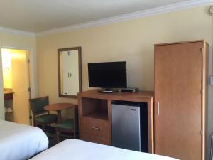 a hotel room with a bed and a desk with a television at Surf Motel in San Francisco