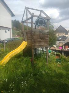 a wooden playground with a slide in the grass at Wildkamp Resort Zelten in der freien Natur ( Wiese Wald ) in Rimbach