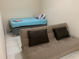 a living room with a couch and a mattress at Apartamento Verão, ideal para vocês in Brasilia