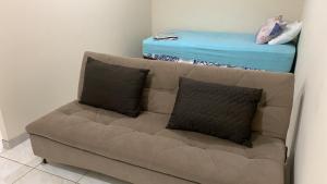 a couch with two pillows in a living room at Apartamento Verão, ideal para vocês in Brasilia
