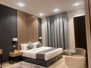 السعادة سويت - الملز الرياض Saada Suites Serviced Apartments في الرياض: غرفة نوم بسرير كنج وطاولة