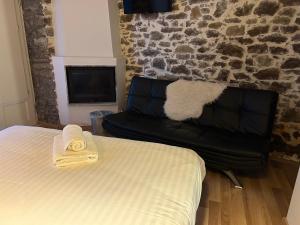 a bedroom with a bed and a black leather couch at Εn Kanaliois in Kanália