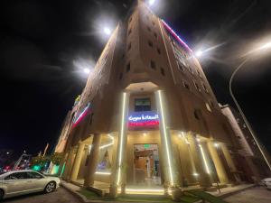 a building with a sign on it at night at السعادة سويت - الملز الرياض Saada Suites Serviced Apartments in Riyadh