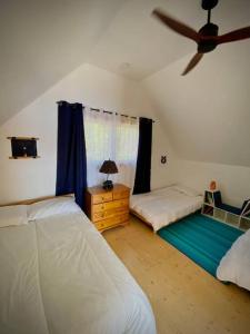a bedroom with two beds and a ceiling fan at Four Season Cottage with Wood Burning Sauna in Ompah